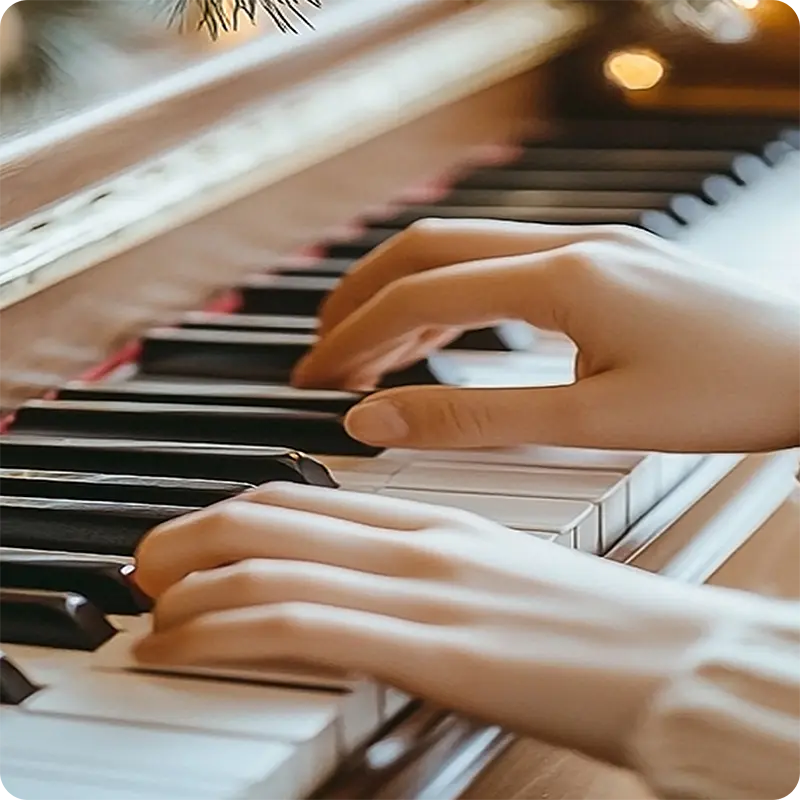 Hands playing Jingle Bells on a piano.