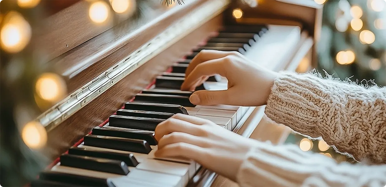 Hands playing Jingle Bells on a piano.